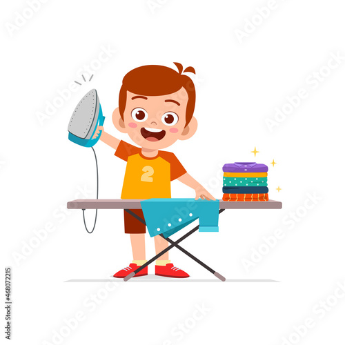 little boy use electric iron to smooth clothes