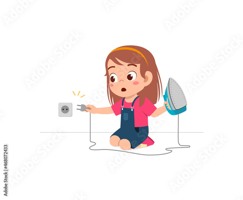 little girl curious to plug in electric iron to wall outlet