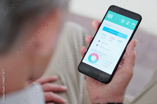 Close-up image of senior man checking micronutrient chart and consumed calories on smartphone
