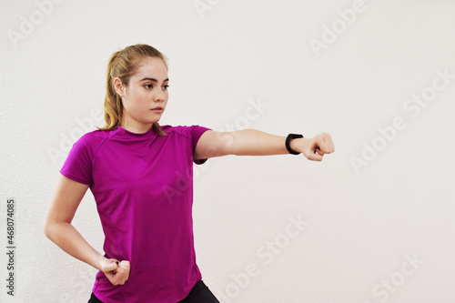 Mujer joven Guatemalteca entrenando artes marciales en casa. Chica Joven lanzando un golpe con la mano. photo