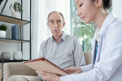 Senior man listening to doctor enumerating list of prescribed medicine