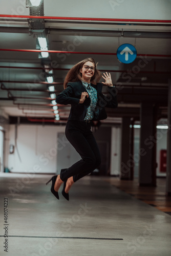 A successful business woman celebrates her job by jumping into the air. Selective focus