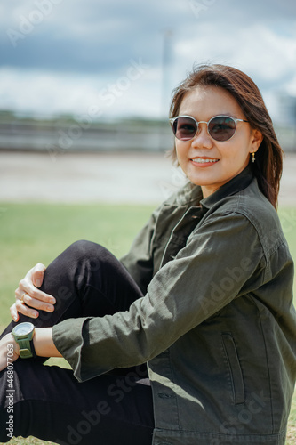 Young Beautiful Asian Woman Wearing Jacket And Black Jeans Posing Outdoors