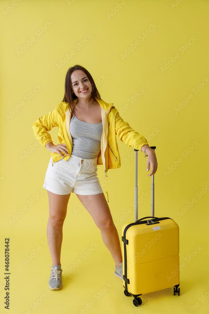 Cheerful woman with travel bag standing in studio Cheerful woman with travel bag standing in studio