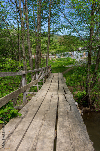 Wooden bridge  in summer in a mountain chalet  crossing a small river in retro style.