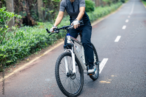 Riding a bike on tropical park trail © lzf