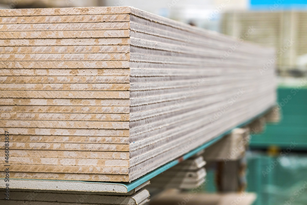 A stack of gypsum fiber sheet moisture-resistant close-up, texture. Construction industry. A stack of gypsum fiber sheet moisture-resistant close-up, texture. Construction industry.