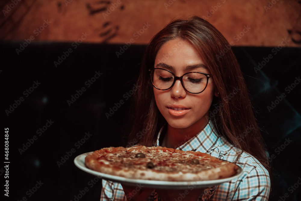 A business woman on a lunch break eating pizza in a modern restaurant. Selective Focus A business woman on a lunch break eating pizza in a modern restaurant. Selective Focus