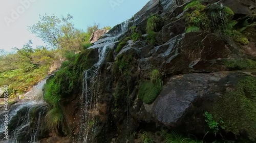 Close-up of travelling upwards at the Casariños waterfall in Fornelos, sunny day, Galicia Spain photo