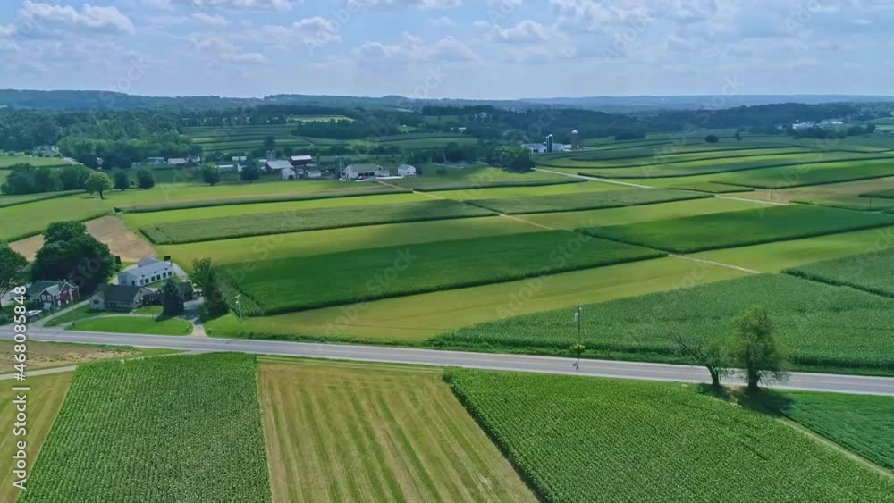 An Aerial Traveling View of Corn Fields and Harvesting Crops, with Patches of Color on a Beautiful Summer Day An Aerial Traveling View of Corn Fields and Harvesting Crops, with Patches of Color on a Beautiful Summer Day