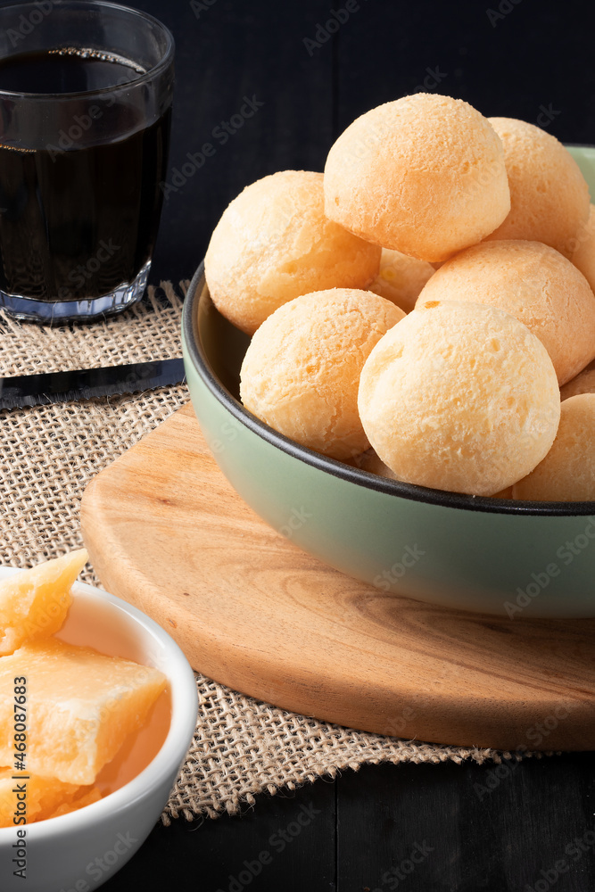 Traditional Brazilian cheese bread (pão de queijo) in a green bowl .