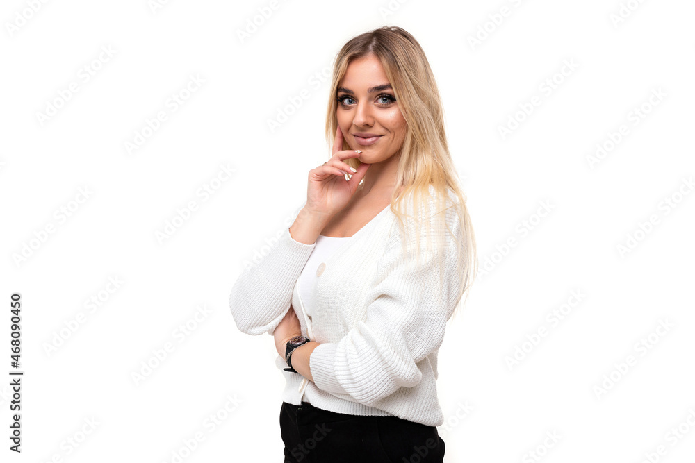 Photo of a charming beautiful pretty amazing positive young blonde woman with makeup in a stylish white knitted sweater and black pants isolated on a white background with copy space for text Photo of a charming beautiful pretty amazing positive young blonde woman with makeup in a stylish white knitted sweater and black pants isolated on a white background with copy space for text