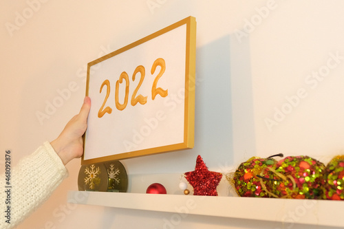  woman hand holding and putting picture frame with 2022