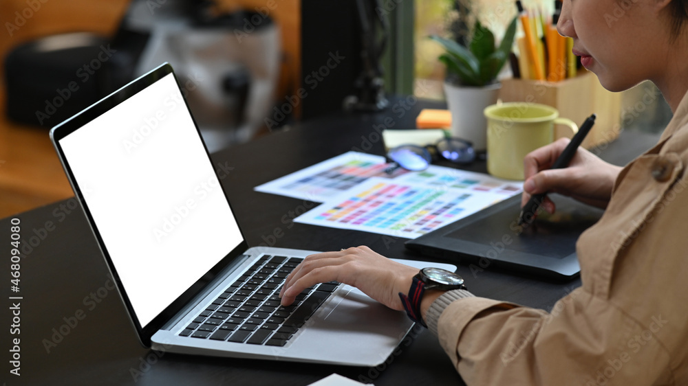 Young creative designer woman working with laptop computer and graphic tablet. Young creative designer woman working with laptop computer and graphic tablet.