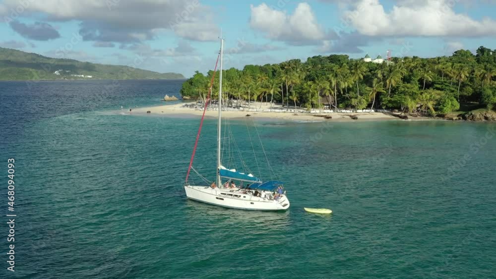 Aerial circling around isolated sailboat moored on emerald waters near Cayo Levantado in Dominican Republic Aerial circling around isolated sailboat moored on emerald waters near Cayo Levantado in Dominican Republic