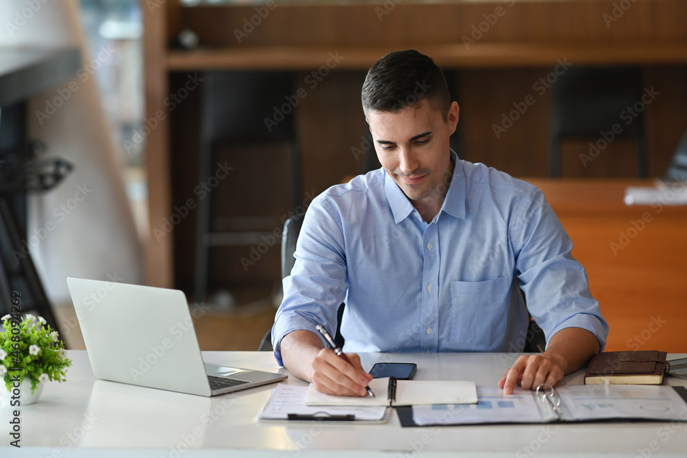 Confident businessman checking reports at his office desk. Confident businessman checking reports at his office desk.