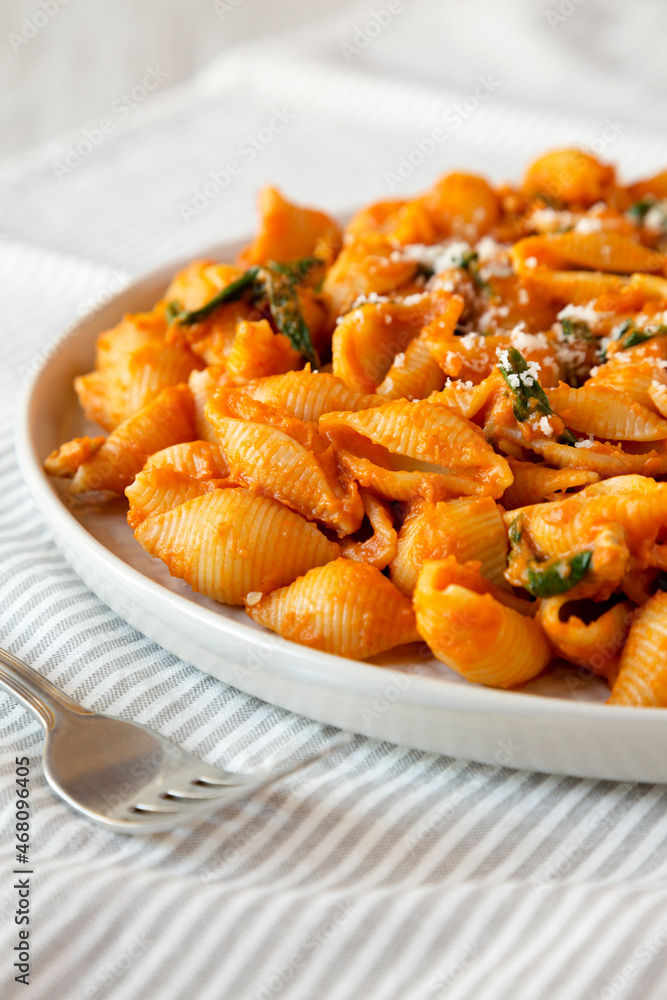 Homemade Pumpkin Pasta with Walnuts and Spinach, side view. Close-up. Homemade Pumpkin Pasta with Walnuts and Spinach, side view. Close-up.