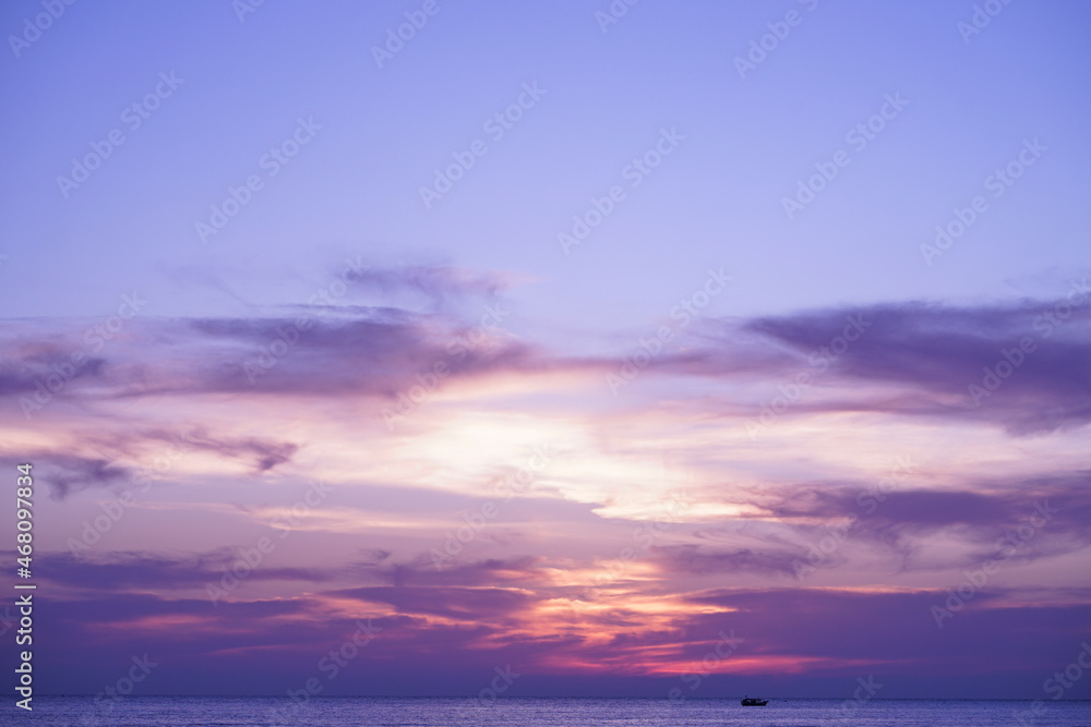 Silhouette of fisherman boat in the ocean at twilight sky.