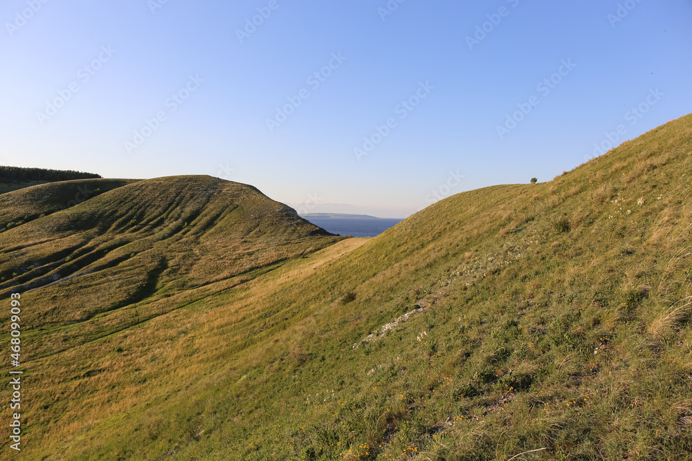 hills with grass landscape at sunset hills with grass landscape at sunset