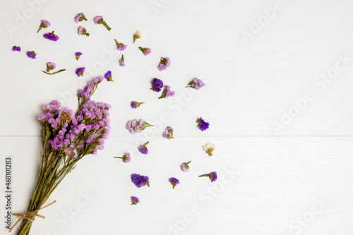 A bouquet of lavender flowers with leaves over the white wooden table. 