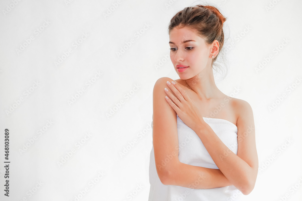 Beautiful young woman posing hand on the face wearing white towel Beautiful young woman posing hand on the face wearing white towel