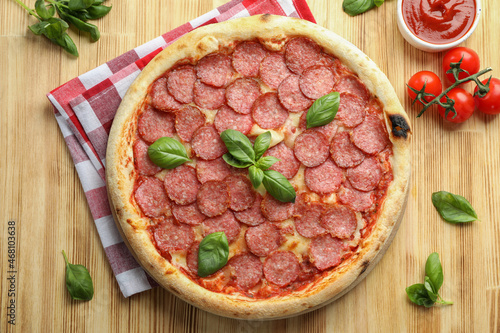 Concept of tasty food with Salami pizza on wooden background