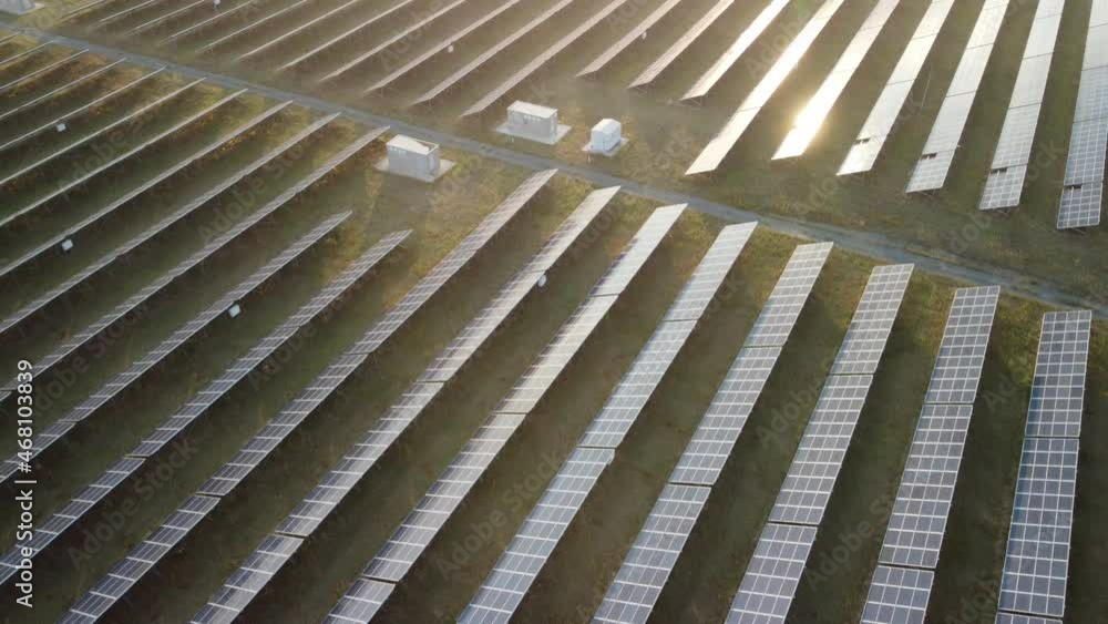 Aerial top view of a solar panels power plant. Photovoltaic solar panels at sunrise and sunset in countryside from above. Modern technology, climate care, earth saving, renewable energy concept. Aerial top view of a solar panels power plant. Photovoltaic solar panels at sunrise and sunset in countryside from above. Modern technology, climate care, earth saving, renewable energy concept.
