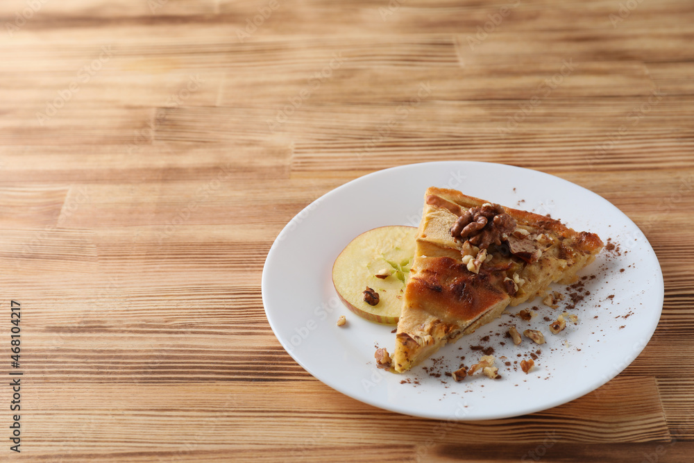 Piece of apple pie on plate on wooden background Piece of apple pie on plate on wooden background