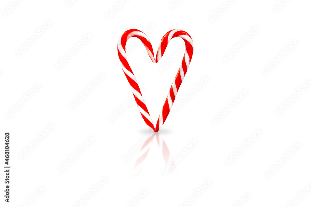 Christmas bright striped lollipop sticks are folded in the form of heart. Isolated on a white background Christmas bright striped lollipop sticks are folded in the form of heart. Isolated on a white background