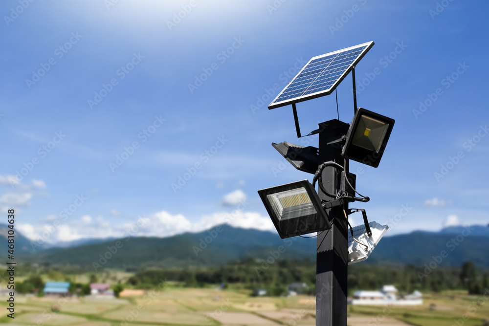 Photovoltaic panel systems and hd floodlights on black metal pole in public park, soft and selective focus. Photovoltaic panel systems and hd floodlights on black metal pole in public park, soft and selective focus.