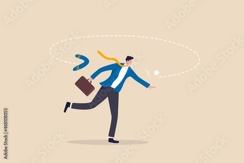 Karma boomerang, sin or consequence of evil action return to himself, disaster and responsibility concept, businessman throw boomerang and it return to hurt himself. photo