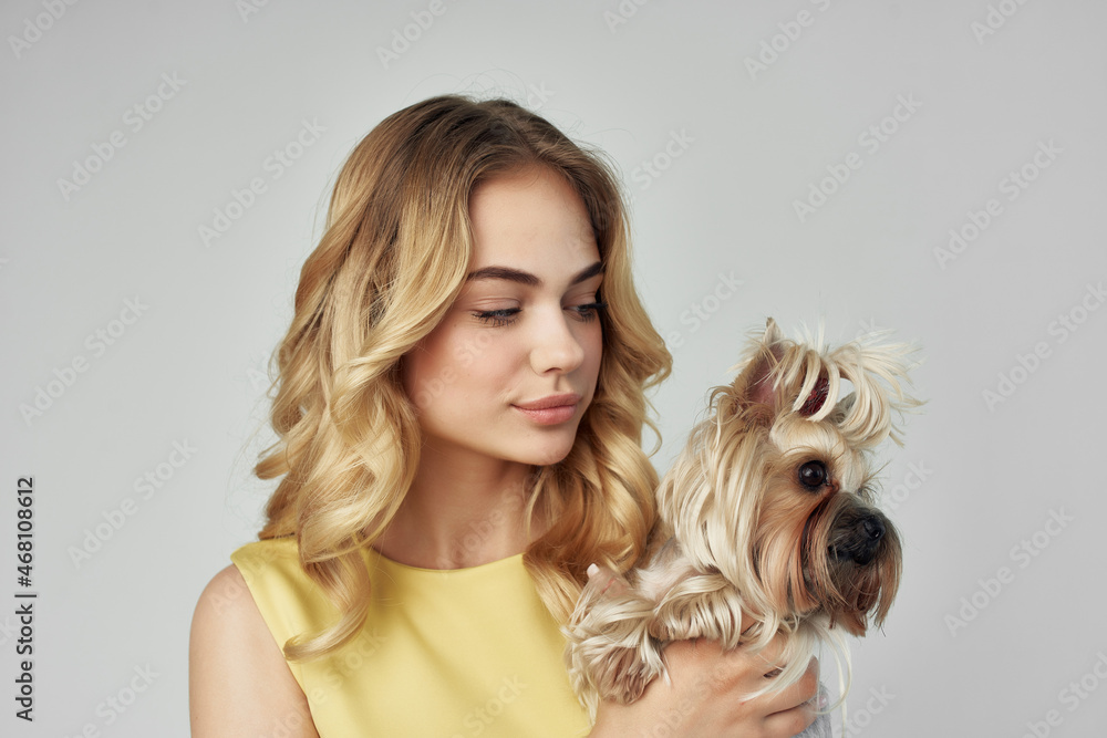 woman in a yellow dress fun a small dog cropped view fashion