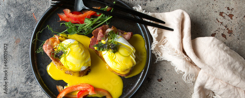Quadro em tela a plate of eggs benedict with hollandaise sauce on the table