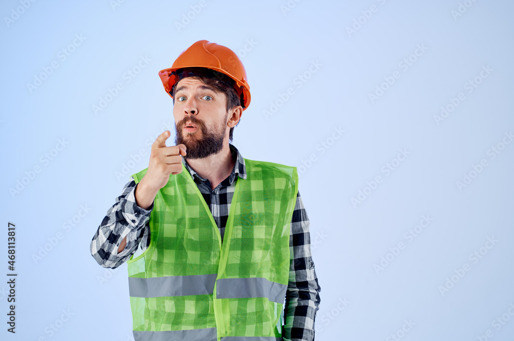 working man green vest orange helmet workflow hand gestures blue background