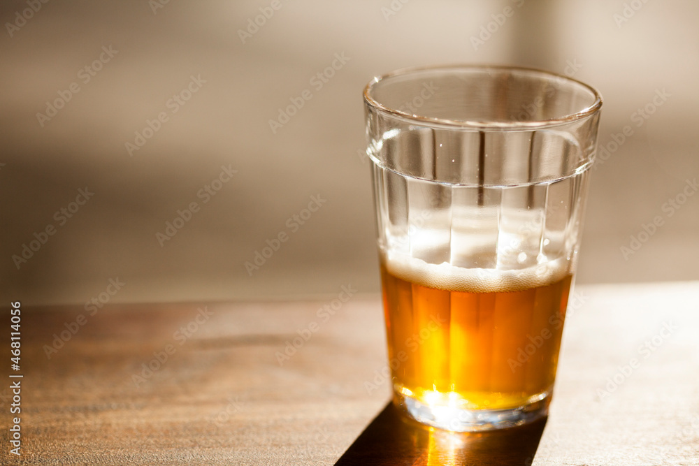 Beer pouring from bottle into glass on a sunny day. High quality photo