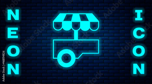 Glowing neon Fast street food cart with awning icon isolated on brick wall background. Urban kiosk. Vector