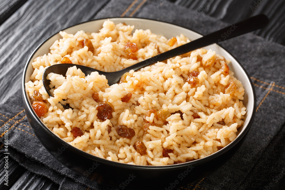 Coconut pilaf rice with raisins close-up in a bowl on the table. horizontal Coconut pilaf rice with raisins close-up in a bowl on the table. horizontal