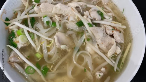 Pho Ga, Vietnamese chicken noodle soup. Stirring delicious, hot asian broth in a bowl.