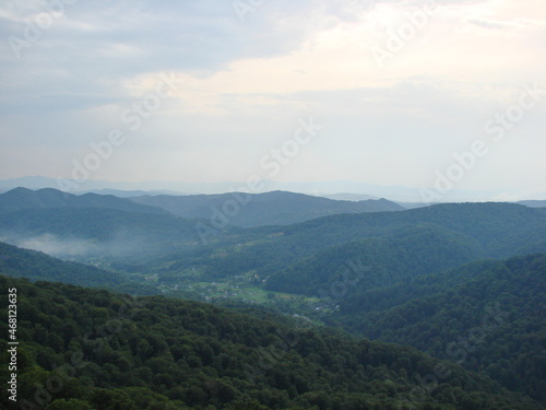 Panorama of cloudy sky over endless mountain ranges covered with a green carpet of Transcarpathian forests.