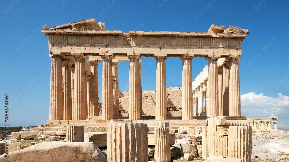 Parthenon temple on a bright day with blue sky. Panoramic image taken in Acropolis hill in Athens, Greece. Classical ancient Greek civilization landmark, famous place, panoramic travel background.