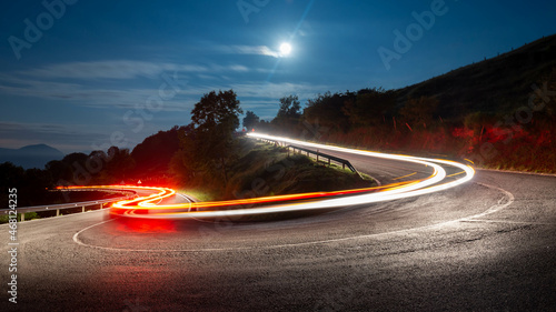 Billede på lærred Estelas de luz en una carretera de montaña