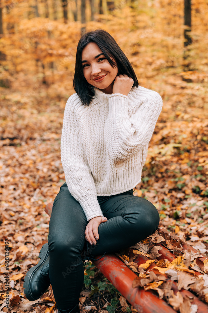 Portrait of young woman in the woods during the colourful fall season. happy girl posing in the forest. Portrait of young woman in the woods during the colourful fall season. happy girl posing in the forest.