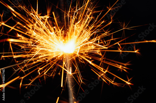 Close view of sparkler on black background. soft selective focus. abstract bokeh background, copy space. Christmas or New Year composition. Christmas card.