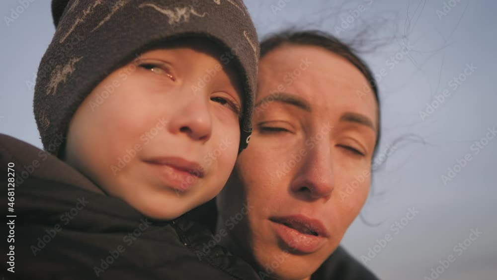 Cute sad boy is crying, mom is kissing her, trying to calm the child. Mommy soothes baby. Loving young mother hugs and soothes her little son. Cute sad boy is crying, mom is kissing her, trying to calm the child. Mommy soothes baby. Loving young mother hugs and soothes her little son.