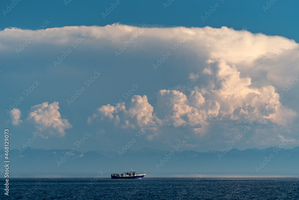 Ship on Lake Baikal under cumulus clouds