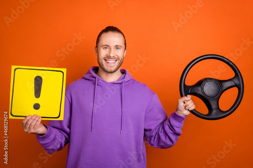 Photo of funky young brown tail hairdo guy drive car hold sign wear purple sweatshirt isolated on orange color background photo