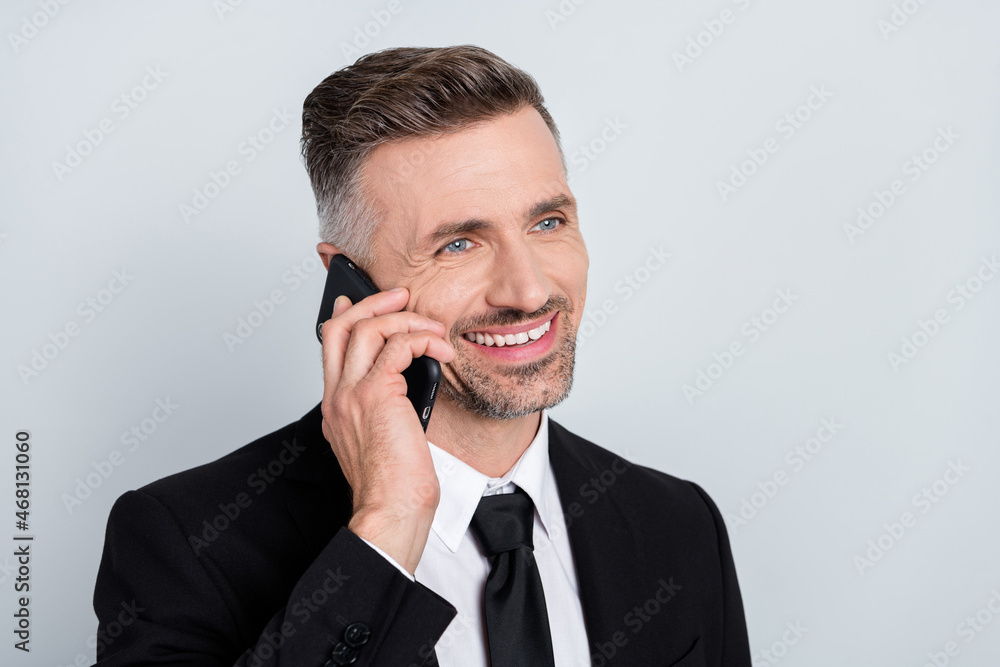 Photo of smiling happy young insurance agent wear black jacket communicating modern device isolated grey color background Photo of smiling happy young insurance agent wear black jacket communicating modern device isolated grey color background