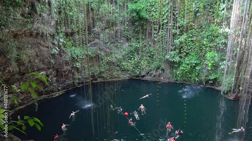Tourists are swimming in the  Ik Kil Cenote. Tinum Municipality, Yucatan, Mexico