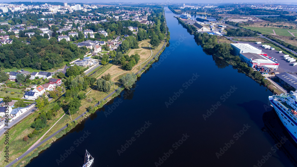Top view of the canal de mer in Caen. A photo from a drone, a sailing sailboat, ships and cranes are visible