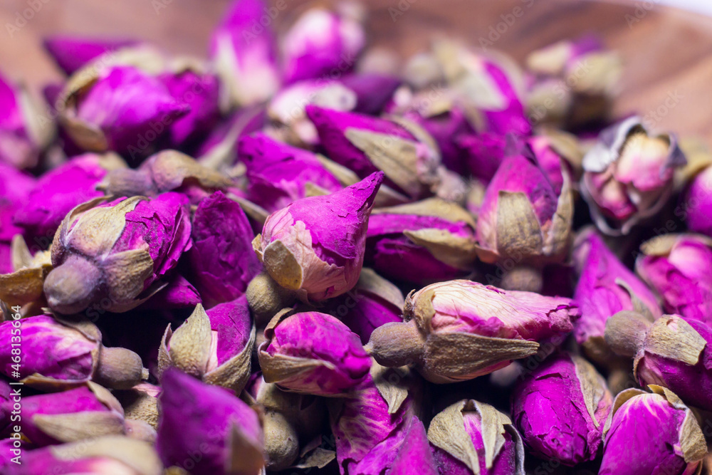 Macro picture of Dried Purple Rose buds on the wood plate.Aromatic of rose for tea .Harvest ,House plants ,Organic garden .